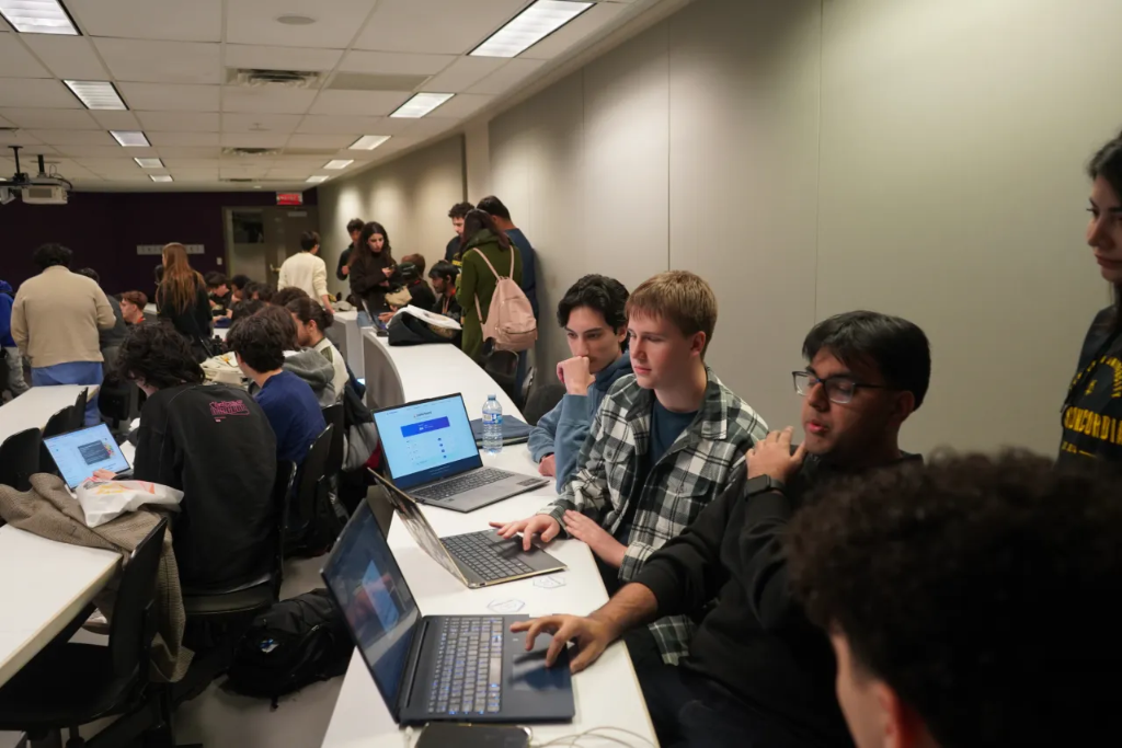Students collaboratively coding on laptops during HackDécouverte